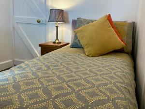 ポルペロにあるTeana Cottageのベッド(枕付)、ランプが備わります。