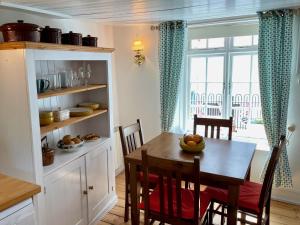a kitchen with a table and chairs and a window at Teana Cottage in Polperro