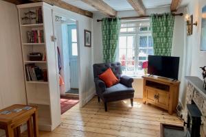 a living room with a chair and a television at Teana Cottage in Polperro