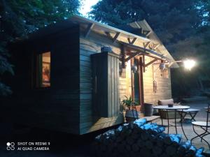 een kleine blokhut met een patio in de nacht bij Chalet libellule Domaine de la Mamounette in Champclause