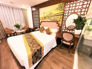 a hotel room with a bed and a desk and a table at DE LA SOIE Hotel & Travel in Hanoi