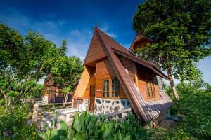 una pequeña casa de madera con techo de gambrel en Panya Garden Resort, en Ban Huai Na