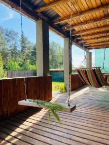 a porch with a swing and a hammock on a deck at садиба доличі in Bovkun