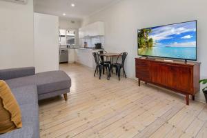 un salon avec une grande télévision à écran plat dans l'établissement Stay Here On Pier- 2 Bdrm Sleeps 4 Beach Wifi, à Glenelg