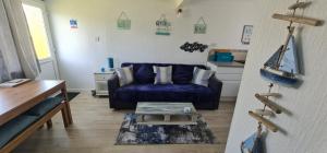 uma sala de estar com um sofá azul e uma mesa em Isle of Wight Chalet em Sandown
