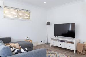 a living room with a couch and a flat screen tv at Brewers Haus Mainstreet Willunga 2 bdrm sleeps 4 in Willunga