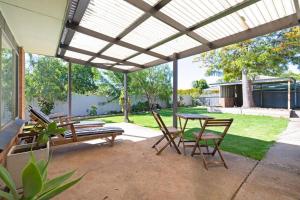 a patio with a table and chairs under a pergola at Brewers Haus Mainstreet Willunga 2 bdrm sleeps 4 in Willunga