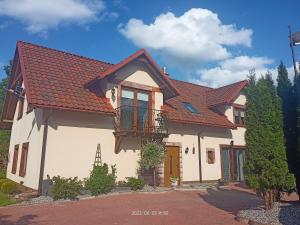 una gran casa blanca con techo rojo en Cicha Dolina, en Wydminy