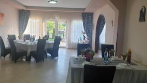 a dining room with tables and chairs and a window at Pensiunea Vila Maria in Crăcăoani