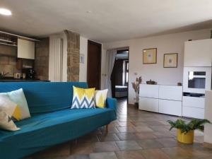a living room with a blue couch and a kitchen at CASA GAIA in Trivigno