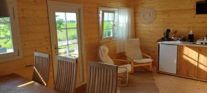 WarstiensにあるSleat - Camping Buorren1の木造キャビンのキッチン(白い椅子付)