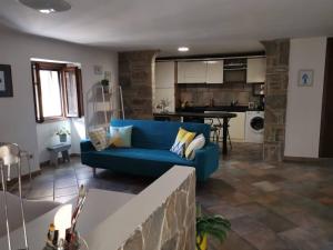 a living room with a blue couch and a kitchen at CASA GAIA in Trivigno