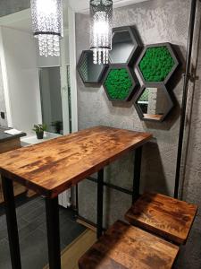 a wooden table and a bench in a room at Дизайнерская квартира в ста метрах от городского парка in Petropavlovsk