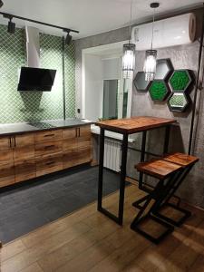 cocina con mesa y silla en una habitación en Дизайнерская квартира в ста метрах от городского парка, en Petropavlovsk