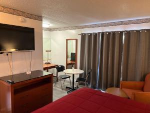 Una habitación de hotel con una cama y un televisor de pantalla plana. en American Inn - Perris, en Perris 12 fotos más