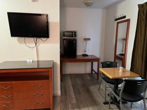 sala de estar con TV y mesa con sillas en American Inn - Perris, en Perris
