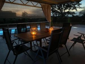 een houten tafel met kaarsen en stoelen op een patio bij Aleya FERIENHAUS mit Pool in Medulin