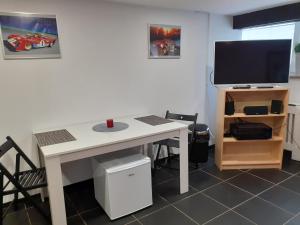 een wit bureau met een tv en een computermonitor bij Stadt nahes Zimmer im Zentrum von Unna in Unna