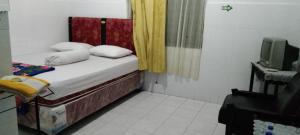 ParepareにあるEXPRESS O 91176 Hotel Puri Gandariaの小さなベッドルーム(ベッド1台、テレビ付)