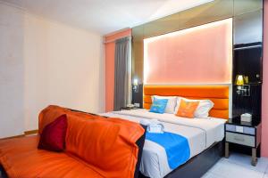 una camera d'albergo con letto e divano di Sans Hotel International Surabaya a Gubeng