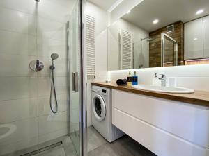 une salle de bain avec une machine à laver et un lavabo dans l'établissement BP Apartment, à Toruń