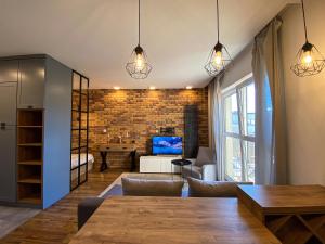 un salon avec une table et un salon avec un mur en briques dans l'établissement BP Apartment, à Toruń