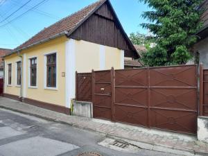 une petite maison avec un garage marron et blanc dans l'établissement La Pablito, à Mediaş
