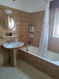a bathroom with a tub and a sink and a shower at Casa do Doque in Vila Nova de Foz Coa