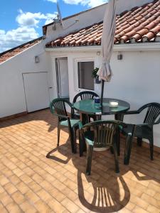 a patio with a table and chairs and an umbrella at Casa do Doque in Vila Nova de Foz Coa