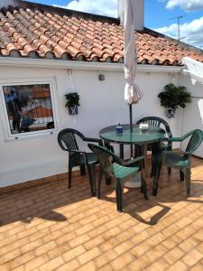 un patio con mesa, sillas y sombrilla en Casa do Doque, en Vila Nova de Foz Cõa