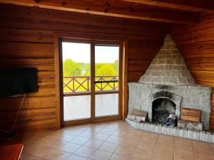 a living room with a fireplace and a sliding glass door at Skrajna Chata Chrzypsko in Chrzypsko Wielkie