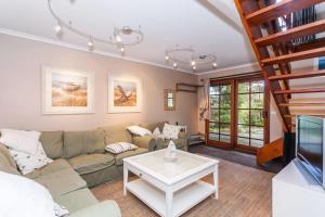 Una sala de estar con un sofá y un televisor. en Waverley Retreat, en Lorne