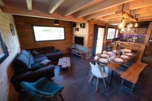 een woonkamer met een bank en een eetkamer bij TOUT NEUF - Chalet Paul avec sauna in La Bresse