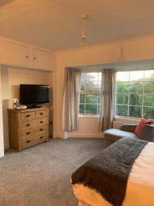 a bedroom with a bed and a flat screen tv at Bosloe in Helston