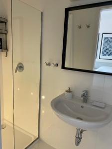 a white bathroom with a sink and a mirror at Tre Re Inn in Rijeka