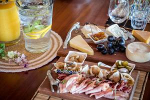 a wooden table with cheese and meats and a drink at Makumu Private Game Lodge in Klaserie Private Nature Reserve