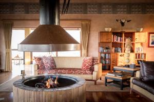 sala de estar con sofá y hoguera en Makumu Private Game Lodge, en Reserva Natural de Klaserie