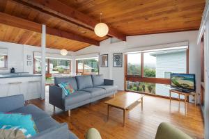 a living room with a couch and a tv at 17 Dulling Street Beach House in Dalmeny
