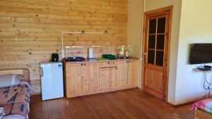 a kitchen with a refrigerator and a wooden wall at Jaunveiti in Bernāti