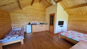a room with two beds and a kitchen in a cabin at Jaunveiti in Bernāti