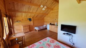a room with a wooden ceiling with a television in it at Jaunveiti in Bernāti