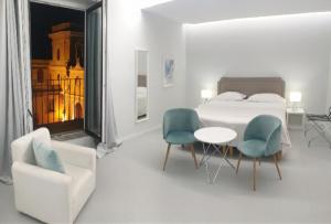 - une chambre avec un lit, deux chaises et une table dans l'établissement Younique, à Sorrente