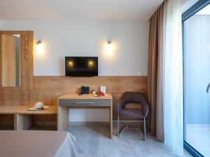 um quarto com uma secretária, uma cadeira e uma televisão em D-Elegant Lapad Dubrovnik em Dubrovnik