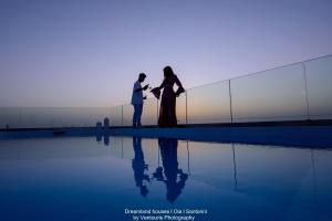 a man and a woman standing next to a fence at Dreamland Ηouses in Oia