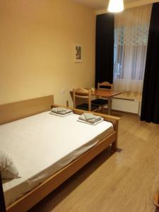 a bedroom with a bed and a table in it at Прекрасен апартамент в Бургас in Burgas