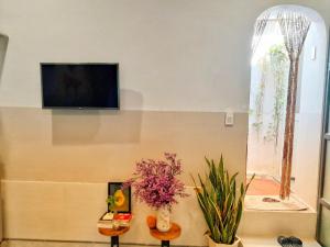a living room with a flat screen tv on the wall at The Quy Nhon Beach House with a Garden in Quy Nhon