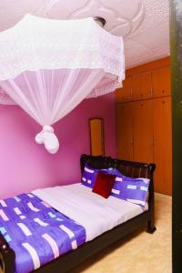 カンパラにあるPrax suitsの紫の壁のベッドルーム1室 +27枚の写真