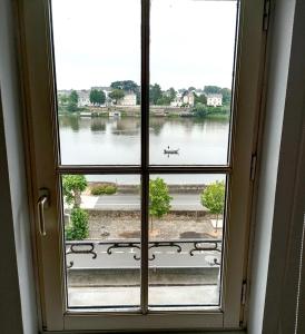 an open window with a view of a lake at T2 vue sur Loire local vélo in Saumur