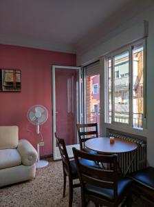 uma sala de estar com um sofá, uma mesa e cadeiras em LUCERO APARTAMENTO em Madri