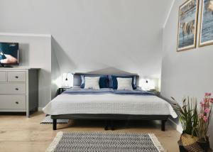 - une chambre avec un grand lit et des oreillers bleus dans l'établissement Apartament GRAY CRANE, à Giżycko